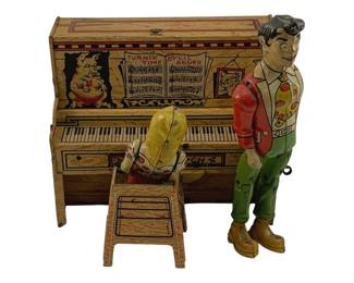 862 - Unique Arts Li'l Abner Tin Litho Piano Toy (Description): Unique Arts tin lithograph wind-up toy featuring Li'l Abner and Daisy Mae at an upright piano. The colorful toy depicts Daisy Mae seated at the piano bench while Li'l Abner stands beside her. The piano is decorated with lithographed imagery including sheet music titled "Turnip Time by Li'l Abner" and character portraits. Both figures are dressed in their signature colorful attire. Measures 7 1/2" x 10" x 6".