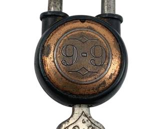 632 - 9-9 Padlock w/ Key 2"x1" (Description): Vintage 9-9 padlock with original key. The lock features a distinctive copper-toned face with embossed 9-9 branding. Measures 2 inches by 1 inch.
