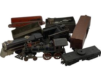 1200 - Lot Assorted Vintage Toy Trains AS IS (Description): Lot of assorted vintage toy trains sold as is. The collection includes a cast iron locomotive with red wheels, various freight cars including gondolas and a boxcar, a Lionel Lines tender, and additional train components. The pieces show age-appropriate wear consistent with vintage toys. Sold as is condition.