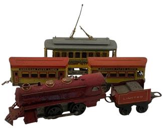 1125 - 5pc. Lot O Scale Trains (Description): A collection of five O scale toy trains including American Flyer Lines passenger cars with red and yellow lithographed tin bodies, a vintage trolley car with rooftop pantograph in yellow and green livery, a red steam locomotive, and a matching red tender marked "Limited." The set shows charming vintage wear consistent with age and play. Measurements: 3.5" x 4.5" x 2".