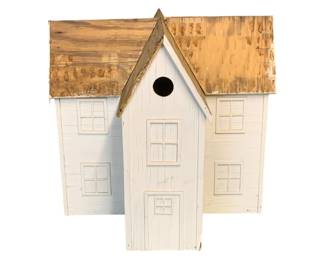 1138 - Wood Birdhouse 19"x19.5"x19.5" (Description): Charming wooden birdhouse featuring a white painted exterior with decorative window and door details. The three-section farmhouse-style design includes a central tall section flanked by two shorter wings, each topped with rustic weathered wood roofs. A single entry hole is positioned at the front center. Measures 19 inches by 19.5 inches by 19.5 inches.