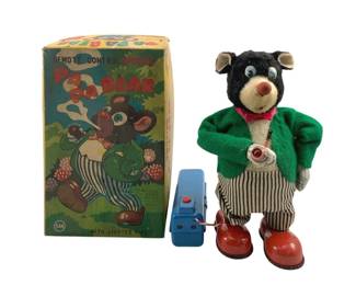 830 - SAN Remote Control Smoking Papa Bear w/ Box (Description): SAN Remote Control Smoking Papa Bear with original box. This charming vintage battery-operated toy features a plush bear dressed in a green felt jacket, red bow tie, and black and white striped pants with red shoes. The bear holds a pipe with a lighted feature and comes with its blue remote control unit. The colorful original box depicts the bear smoking his pipe. Measures 8 inches tall.