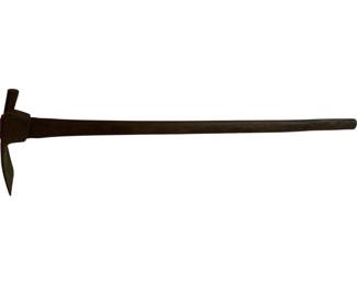 1167 - Antique Hoe Tool 31"x8"x4" (Description): Antique hoe tool featuring a wooden handle with a metal head. The head has a pick on one side and a flat blade on the opposite side, characteristic of a mattock or pick-axe style hoe used for breaking up hard soil and roots. The tool shows a well-worn patina consistent with age and use. Measures 31" x 8" x 4".