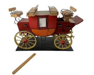 751 - Vintage Stagecoach Model w/ Damage 9"x13"x6" (Description): Vintage stagecoach model with damage. This decorative piece features detailed construction with multiple seating areas and spoked wheels mounted on a display base. Measures 9 inches by 13 inches by 6 inches.
