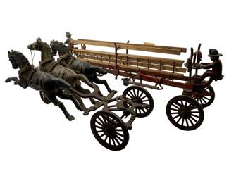 25 - Cast Iron Toy Fire Wagon & Horses (Description): Antique cast iron toy fire wagon with horse team. This charming piece features three galloping horses pulling a ladder wagon with two firemen figures. The wagon carries wooden ladders and rolls on spoked wheels. The piece displays a well-worn patina consistent with age and play. Wagon measures 7 inches by 22 inches by 5 inches; horses measure 5.5 inches by 14 inches by 5 inches.