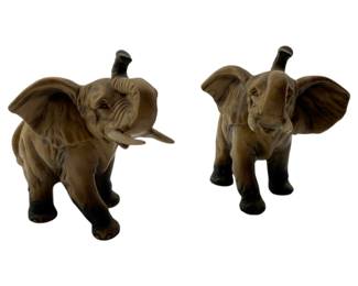 2 - Pr of Vtg Lefton Elephants 3.5"x4"x3" (Description): Pair of vintage Lefton elephants measuring 3 1/2" x 4" x 3". These charming ceramic figurines depict baby elephants with raised trunks and extended ears in playful walking poses. Each elephant features realistic brown and gray coloring with detail texturing and darker accents on the feet and trunk tips.