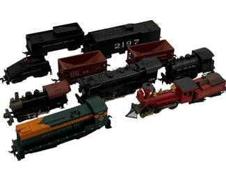 989 - 10pc. Lot HO-Scale Trains & Cars 5"x6"x4" (Description): A collection of ten HO-scale model trains and cars. The lot includes various locomotives and freight cars representing different railroad companies. Measures 5 inches by 6 inches by 4 inches.