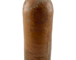 126 - Vtg German Stoneware Mineral Water Bottle (Description): Vintage German mineral water bottle crafted from salt-glazed stoneware in a warm tan/brown color. The bottle features embossed text reading "Ahrweiler" and "Rheinpreussen" along with a circular seal, indicating its origin from the Ahrweiler region of Rhine Prussia. The bottle shows authentic age-related wear including surface patina and mineral deposits consistent with its vintage character. Measures 11 1/2" x 3.5".