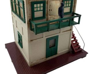 354 - Lionel #445 Switch Tower 10"x10.5"x5.25" (Description): Lionel #445 Switch Tower. This model railroad accessory features a two-story structure with a balcony and figure. Measures 10" x 10 1/2" x 5.25".