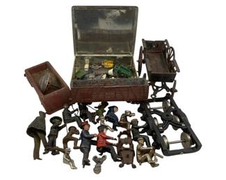 1174 - Group Lot Antique Toys (Description): A group lot of antique toys including cast iron and lead figures, miniature vehicles, and toy machinery parts. The collection features painted metal figures in various poses, a red wagon or cart, a brown livestock car, a horse-drawn cart frame, mechanical toy components, and additional small toys and parts stored in a vintage tin box. The figures include workers, children, and character figures in period dress, showing