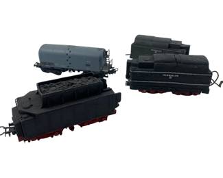 320 - Marklin Train Cars 2"x2"x6" (Description): Collection of Marklin model train cars including a gray tanker car, a black coal tender with simulated coal load, and a black freight car. The cars feature detailed construction with red wheel trucks and metal coupling hooks. Each car measures approximately 2 inches by 2 inches by 6 inches. Shows vintage wear consistent with age and use.