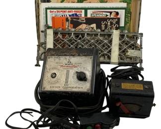1093 - Lot of Vintage Lionel Train Accessories (Description): A lot of vintage Lionel train accessories including a Lionel Corporation Trainmaster transformer with power cord, an additional transformer unit, a multi-button controller with colored indicator lights, a metal lattice-style fence section, and assorted vintage advertising diecut billboards featuring brands such as Du Pont Anti-Freeze and Wrigley's Spearmint gum. The collection represents mid-century model railroad