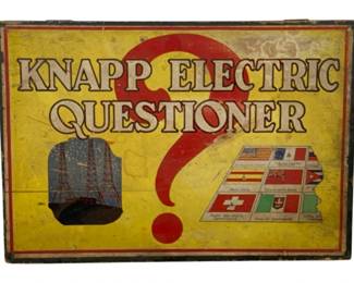 1009 - Knapp Electric Questioner 2.25"x14" (Description): Knapp Electric Questioner vintage educational game. This classic question-and-answer game features an electric mechanism that indicates correct answers. The box lid displays colorful graphics including radio towers and international flags. Measures 2.25 inches by 14 inches.
