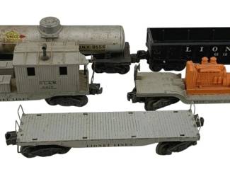 506 - Lot O Scale Trains (Description): A lot of O scale trains including various freight cars. The collection features multiple Lionel Lines pieces including a tank car, caboose, gondola, flatcars, and a car with machinery load.