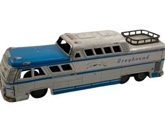 1037 - Greyhound Tin Litho Metal Bus 11.5"x3"x3" (Description): Greyhound tin litho metal bus featuring the classic Scenic cruiser design with the iconic running dog logo and blue and white color scheme. The bus includes a luggage rack on the roof. Measures 11 1/2" x 3" x 3".