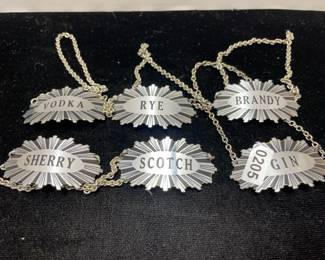 six metal liquor label hangers