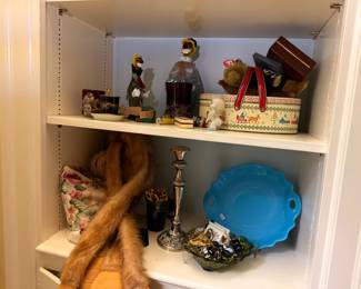 Shelf of figurines, fur stole and blue glass