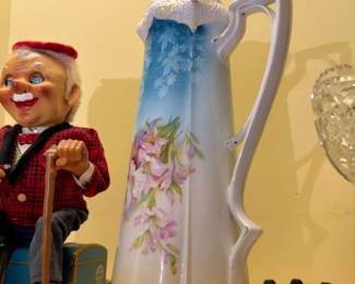 Hand-painted floral porcelain pitcher and vintage toy