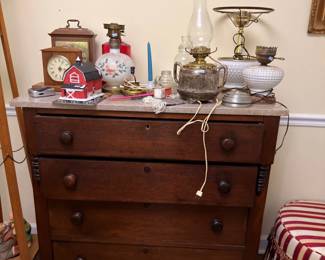 Antique chest of drawers with clocks, oil lamps