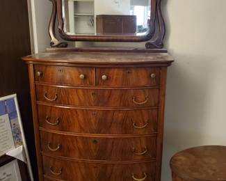 Wishbone mirror atop the burled wood chest of drawers