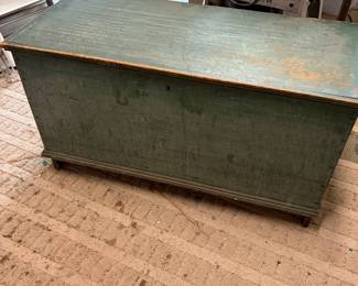 This antique six-board blanket chest features a green painted finish over pine wood consistent with American 19th-century folk art