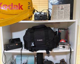 Kodak camera carrying bag, Kodak Instamatic 814 camera, book about the story of Kodak, tele electrolyte camera, Kodak automatic 104 camera, Vivitar 285, Cannon camera in bag with all the accessories, two power shot SD 700 IS digital elph  cameras, Ulta freedom zoom model 1051,  Konica 62 mm lens and Konica FS-1 camera.