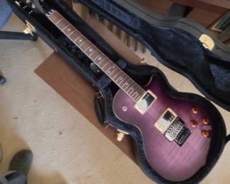 Xaviere PRO555 electric guitar featuring a purple flame maple top and gold hardware.