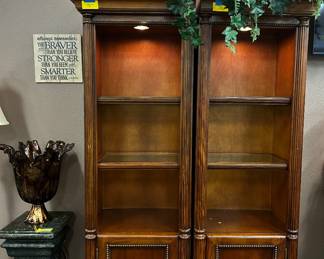 Bookshelves with lights, ornate side table, statement piece of art, wall sconce, faux plant