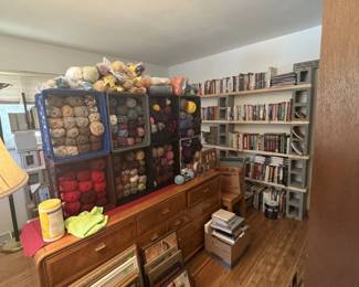 dresser with mirror, artwork, frames, yarn, books