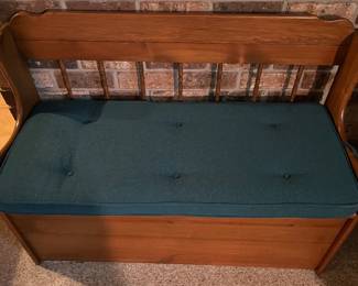 Deacon-style wooden storage bench with cushion.