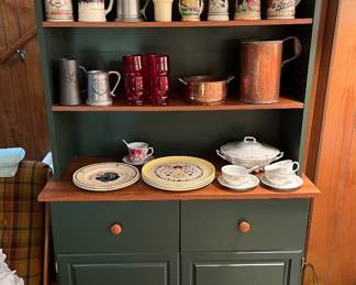 Green kitchen cabinet with shelves.