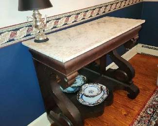 Mahogany Empire server – Flat swans neck supports, oval body panel, Ogee molded apron, double serpentine shelve below, mirrored back underneath apron, 43 ½” x 19”, white marble top, 37 ½” H, Circa 1830