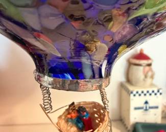 Robbins Ranch hand-blown glass hot air balloons are unique, handcrafted ornaments made in Stanley, New Mexico. Each piece features an intricate wire-wrapped miniature wicker basket (gondola) complete with a tiny "worry doll" pilot