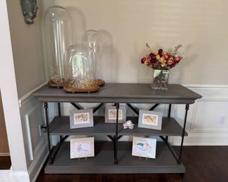 Restoration Hardware console table with iron accents and multiple display shelves.