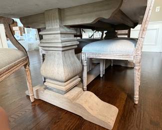 Restoration Hardware dining table featuring a thick stone-look top and architectural pedestal base. Exceptional craftsmanship and scale with carved pedestal supports and weathered oak finish.