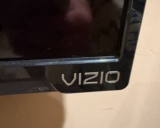 Vizio flatscreen TV, wall mounted with an optional stand