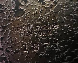 This is tricky to read, but it says, "TIFFANY STUDIOS NEW YORK 167?" To be fair, it could be "167" or "1671"; you be the judge.