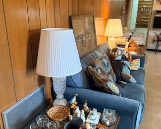 Living room with blue sofa, lamp & glassware
