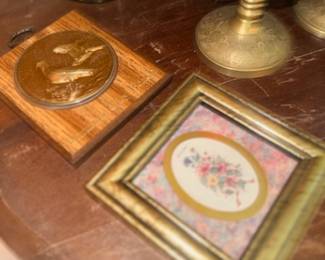 Framed floral needlepoint art and brass medallion