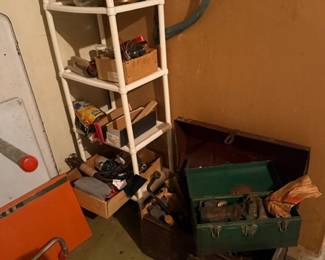 Green metal toolbox and shelving with tools