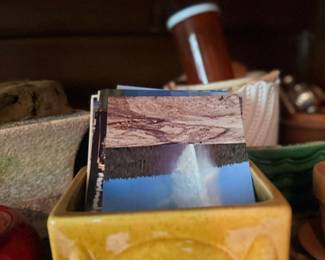 Yellow ceramic planter with vintage postcards