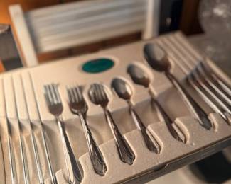 Silver-plated flatware set in storage tray