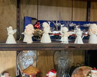 Row of angel figurines and Santa decor