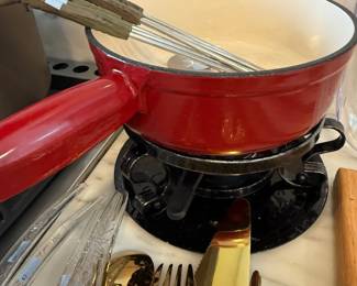 Red enameled saucepan and whisk