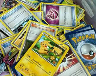 Bin of assorted Pokemon cards, Pikachu and trainer cards