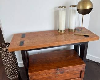 Wood console table with brass lamp and glass hurricanes