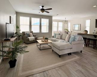 Ivory Sectional, neutral rug, coffee table, floor lamp,  bar stools, tv stand, throw pillows and blankets