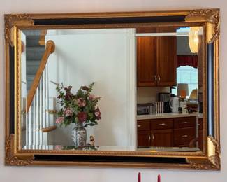 Vintage wall mirror a heavy gold leaf frame, intricate floral corners and black accents