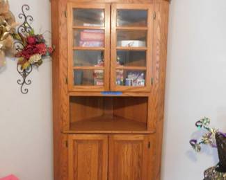 Classic Amish-style corner hutch made from oak wood, featuring a glass-door top for display and closed lower cabinet storage
