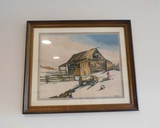 Framed needlepoint artwork featuring a winter countryside barn.